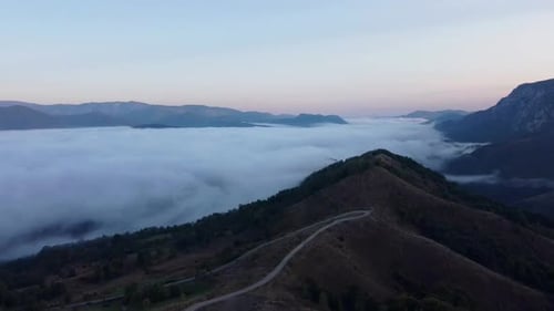 Road In Mountains And Clouds In Background Aerial View
