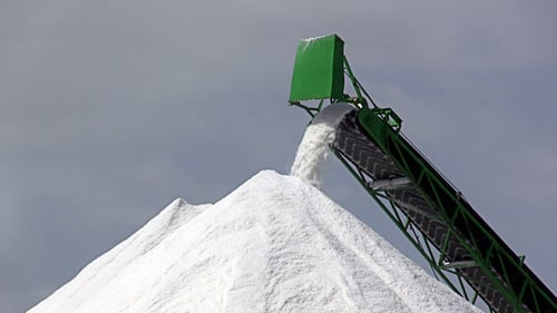 Conveyor Belt Fills Large Pile of White Material