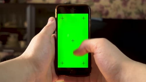 The Man Uses the Phone. Hand Makes Swipe Down on Smartphone with Green Screen. Chroma Key.