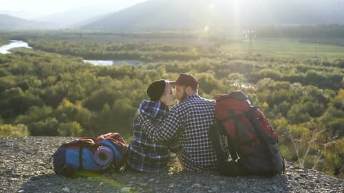 Beautiful Couple Sitting on the Ground in the Mountain