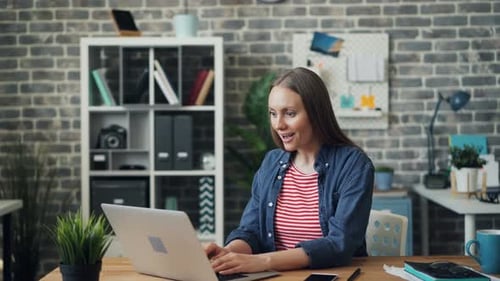 Excited Woman Using Laptop in Office