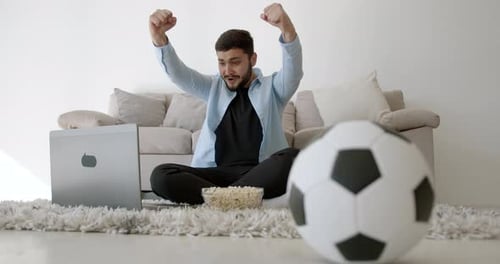 Man Watching Soccer Game on Laptop at Home