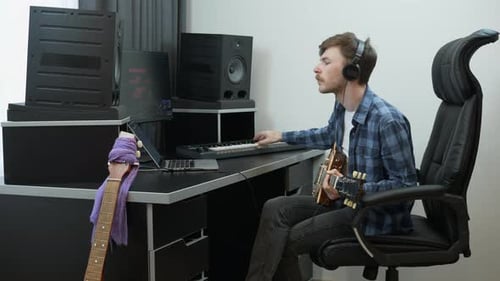 Songwriter composer playing on midi piano keyboard at home music recording studio. Music concept