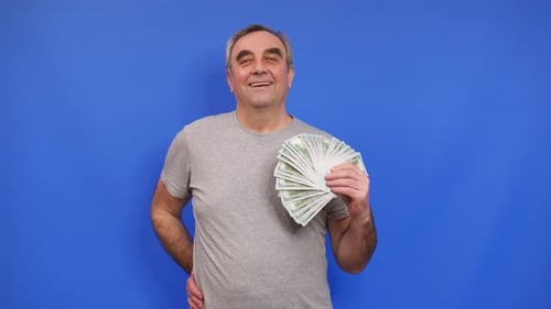 Happy Man Fanning Money on Blue Background