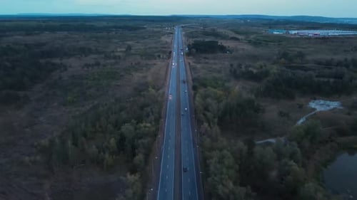 Drone aerial shot of a road passing through rural scene.