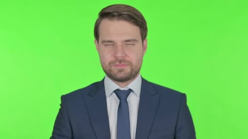 Serious Young Businessman on Green Background