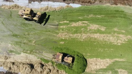 Aerial View of Tractors Spreading Silage on Farmland
