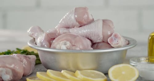 Fresh Raw Chicken Drumsticks and Lemon Close-Up