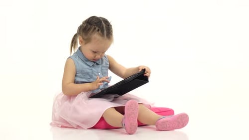Little Girl Uses Digital Tablet at Home