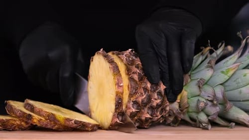 Fresh Pineapple Sliced into Pieces on Cutting Board