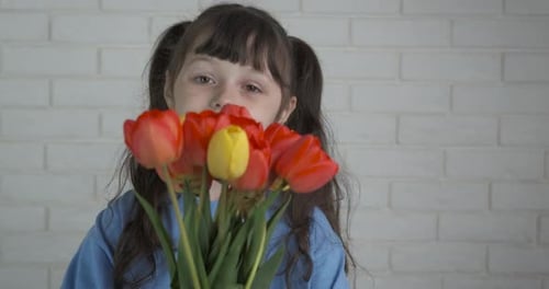 Smiling Girl Holding Bouquet of Colorful Tulips