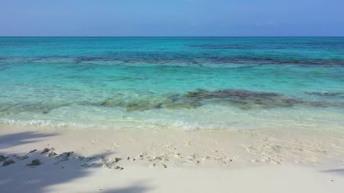 Wide angle birds eye abstract shot of a sunshine white sandy paradise beach and aqua blue water back