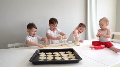 Familienkonzept, Vier Kinder Hilfe ihrer Mutter beim Keksbacken, Pizzabrötchen
