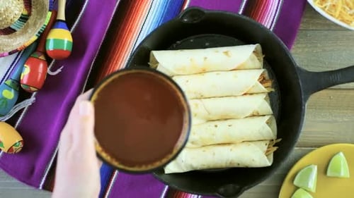 Preparing Delicious Enchiladas with Red Sauce in Skillet
