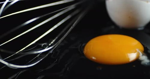Raw Egg with Whisk Slowly Rotates.