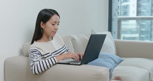 Woman Typing on Laptop in Modern Apartment