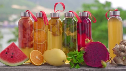 Un ensemble de bouteilles en verre colorées avec différentes saveurs de boissons au kombucha, telles que la pastèque et l'orange