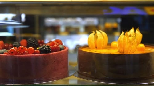Gros plan de gâteaux à base de plantes décorés de baies et de physalis sur un présentoir en végétalien