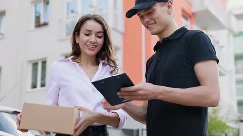 Smiling Woman Receives Package from Delivery Man