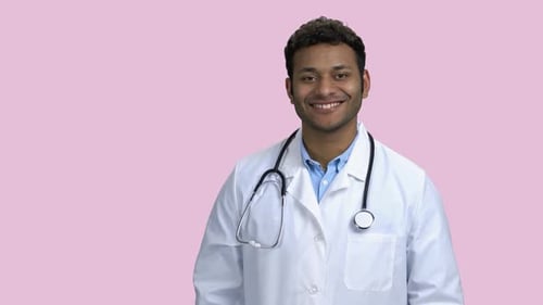 Smiling Male Doctor with Stethoscope on Pink Background.