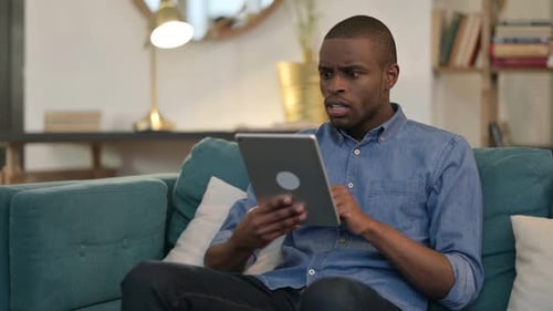 Man Reacts Negatively to Something on Tablet
