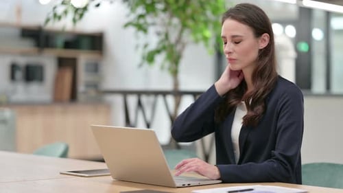 Woman Typing on Laptop in Office Environment