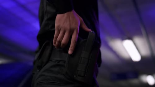 Officer removes pistol from holster at night