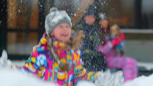 Niña arroja nieve contra madre y padre borrosos