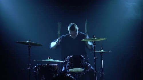 Silhouette-Schlagzeuger spielt auf Schlagzeug auf der Bühne in einem dunklen Studio mit Rauch- und Neonbeleuchtung