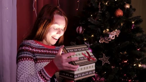 Excited Woman Opening Christmas Gift