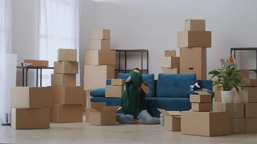 Young Couple Packing Belongings Into Boxes