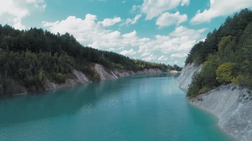 Eine verlassene Gipsgrube mit blauem Wasser.