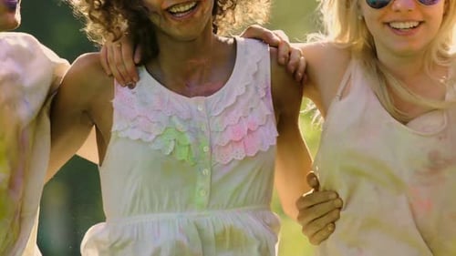 Friends Covered in Paint Walking Together Outdoors