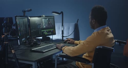 Man in Wheelchair Works at Dual Monitor Computer