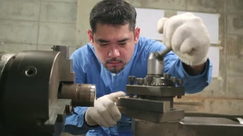 One professional Asian male worker works in metalwork manufacturing factory.