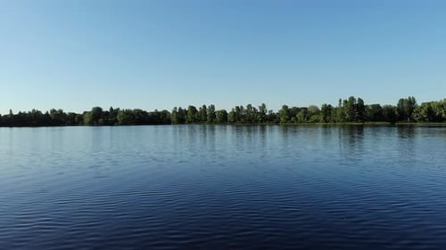 Aerial Drone Footage of Lake and Forest Against Sky