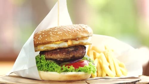 Burger with fries on wooden surface
