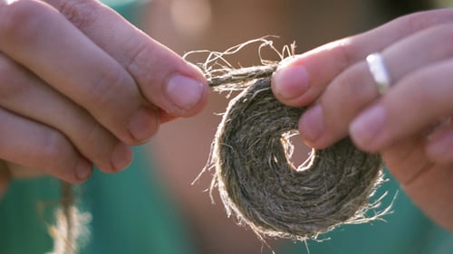 Hands Creating Circle with Rope in Sunlight