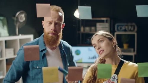 Bearded Man and Beautiful Woman Discussing Business Ideas in Hipster Office