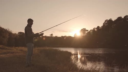 Fisherman with a spinning rod catching fish on a river.