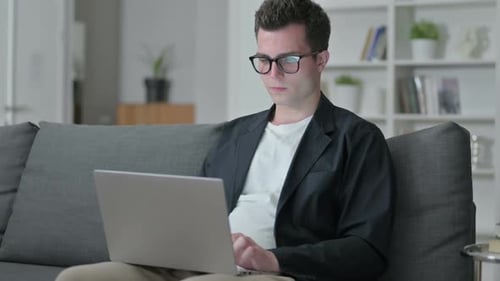 Young Adult Working on Laptop at Home