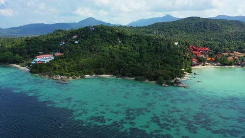 Beautiful turquoise lagoon washing rocky coastline of tropical island with vacation resorts surround