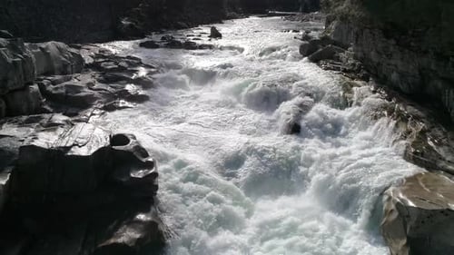 Drohne fliegt über atemberaubenden Flusswasserfall mit Wildwasser-Stromschnellen in ultrarealistischer 4K-Naturaufnahme