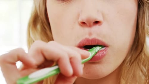 Young Woman Brushing Teeth Close Up