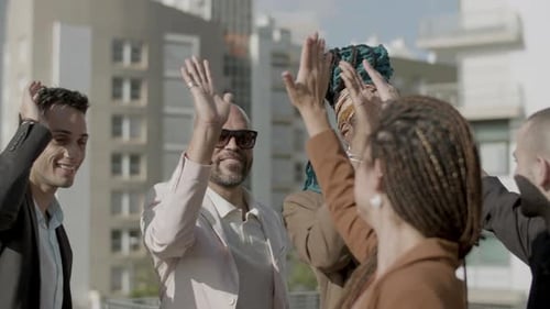 Diverse Team Giving High Five on City Rooftop
