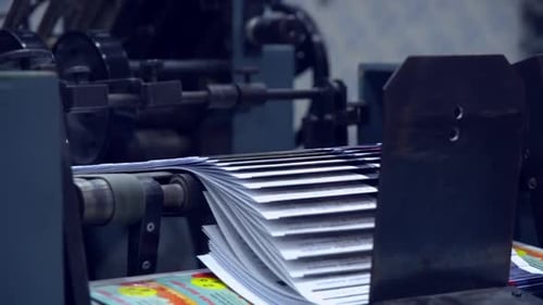 Printing Machine Feeds Paper Through Industrial Press