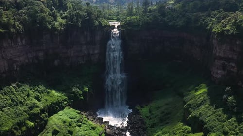 Spectacular Waterfall Surrounded By Lush Greenery