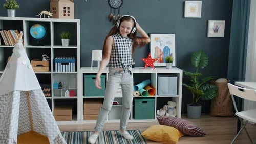 Teen Girl Dancing with Headphones in Her Room