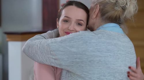 Loving Embrace Between Young Woman and Senior Woman