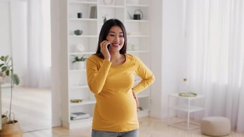 Pregnant Woman Talking on Smartphone in Bright Home